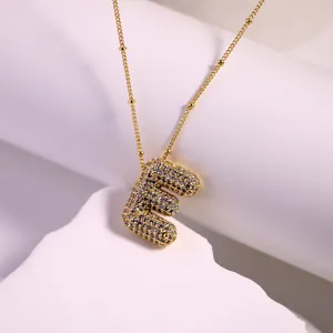 Close-up of gold 18K plated letter E pendant necklace with micro-pave cubic zirconia