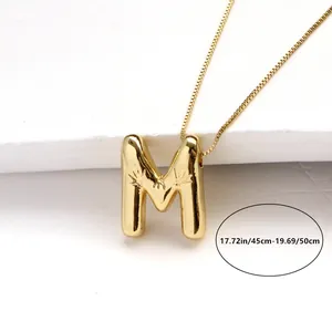 Macro shot of gold letter M pendant with floral engraving and 45-50cm box chain