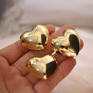 Polierte 18K vergoldete Herzanhänger für DIY-Schmuck auf einer Handfläche präsentiert