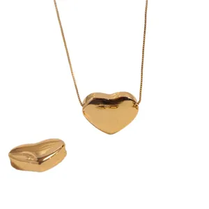 Polished 18K gold 3D heart pendant necklace with delicate chain on a white background