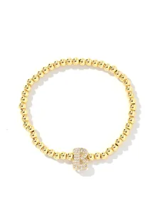 Detail of gold beaded bracelet featuring a sparkling cubic zirconia letter B bubble pendant