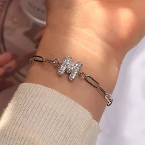 Détail de la gourmette argentée à trombones avec breloque lettre M sertie de zircons