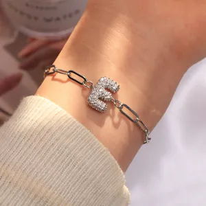 Détail du bracelet chaîne trombone argenté avec un pendentif lettre E serti de zircons