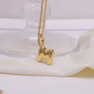 Detailed close-up of 18K gold-plated puffed letter M pendant with shimmering pavé stones