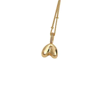 Polished 18K gold heart pendant necklace with twist chain and sparkling crystal accents