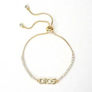 Detail view of the DIOS letter plate on an adjustable 18K gold plated zircon bracelet