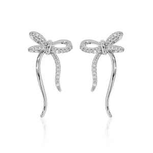 Orecchini a fiocco in argento scintillante con zirconi su sfondo bianco con riflesso chiaro
