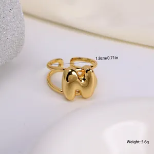 Macro-opname van 1,8cm diameter en gewichtsdetails van de gouden 3D-ring met de letter M