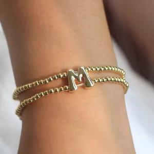 Zweilagiges goldenes Perlenarmband mit poliertem Buchstaben-M-Anhänger im Bubble-Stil