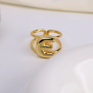 Macro-opname van verstelbare gouden dubbele ring met een opvallende ballonletter E