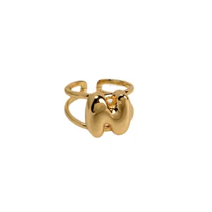 Gouden dubbellaagse open ring met een 3D-letter W in een speelse bubbelstijl