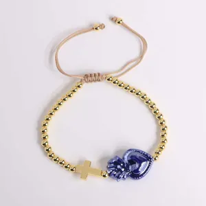 18K gold plated beaded bracelet with cross pendant and blue heart charm on a woven cord