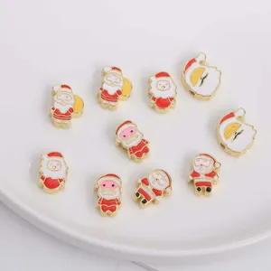 Makroaufnahme verschiedener Weihnachtsmann-Emaille-Anhänger für DIY-Schmuck auf Keramiktablett
