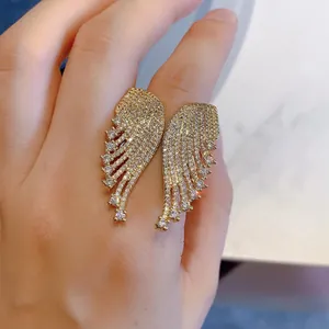 Macro shot of micro-pave zircon angel wing open rings in gold finish worn on hand