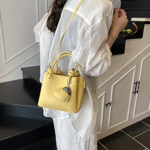 Sac seau jaune texture litchi avec pendentif cœur et bandoulière amovible réglable
