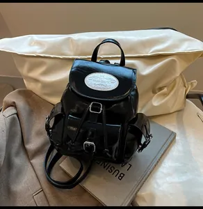 Détail du mini sac à dos en cuir verni noir brillant avec plusieurs poches