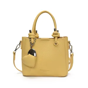 Sac seau à la mode en cuir grainé jaune avec poignée nouée et breloque cœur