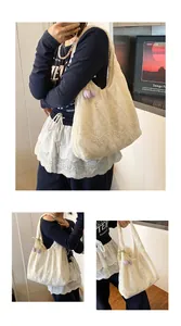 Detail of white lace tote bag featuring floral embroidery and purple tulip pendant