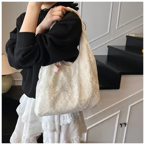 Detailed view of layered white floral lace patterns and soft scalloped edges on the bag