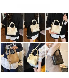 Détails des sacs seaux à motif crocodile en blanc, marron et noir portés par un mannequin