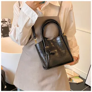 Détails du sac seau noir motif crocodile avec bandoulière réglable et ferrures dorées