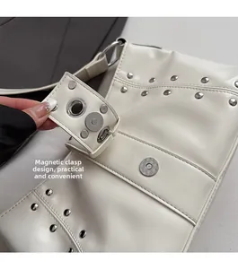 Dettaglio della borsa tote bianca con borchie argentate e chiusura a fibbia magnetica