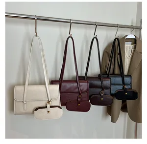 Detail van vier retro schoudertassen in crème, bordeaux, donkerbruin en zwart