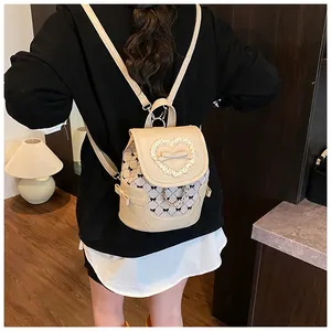Detailed view of mini beige checkered backpack featuring lace hearts and bow accents