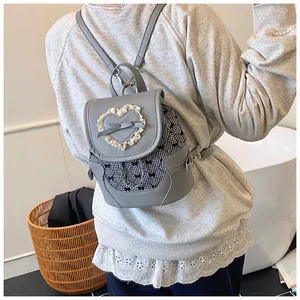 Detail of grey mini backpack with heart lace, bow accents and checkered pattern
