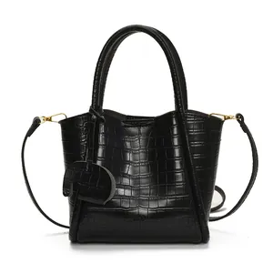 Sac seau élégant en cuir noir motif crocodile avec détails dorés et bandoulière