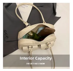 Detail view of large internal capacity of the beige bowling bag with multiple items
