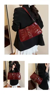 Macro di borsa a spalla in pelle lucida bordeaux con occhielli metallici e borchie
