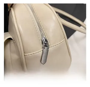 Close-up of premium silver zipper and smooth cream leather texture on bowling bag