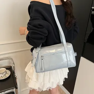 Fashionable light blue glossy pillow shoulder bag for women shown on model with shoulder strap