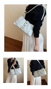 Dettaglio borsa a spalla in pelle verniciata bianca con borchie argento e stile punk Y2K