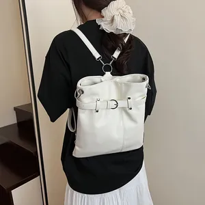 Minimalist beige pleated drawstring backpack with silver hardware in a stylish lifestyle shot