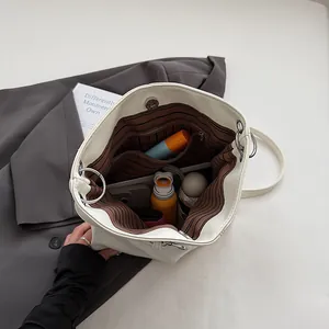 Minimalist white bucket backpack with large capacity storage and striped interior lining