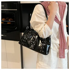 Dettaglio della borsa hobo nera lucida con borchie argentate e grandi occhielli in metallo