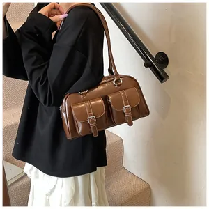 Macro shot of dark brown PU leather shoulder bag featuring vintage metallic buckle pockets