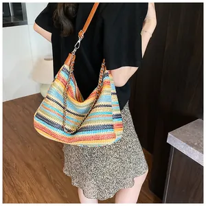 Detailed texture of rainbow woven straw tote with leather strap and metal chain handle