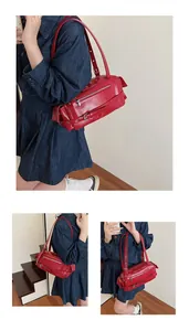 Detailed view of glossy red baguette shoulder bag with silver zippers and buckle straps