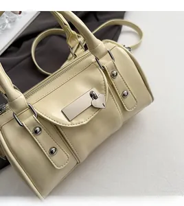 Detail showing the creamy white Boston bag texture with heart-shaped metal lock and silver studs