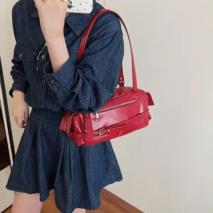 Chic red patent leather baguette shoulder bag with adjustable strap and vintage buckle detail