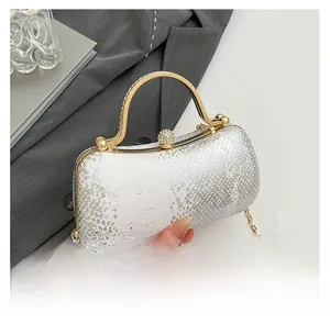 Detail of white snakeskin texture evening bag with gold handle and diamond ball clasp
