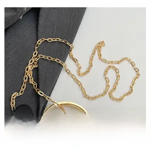 Close-up of golden chain strap and gray snake pattern leather detail on handbag