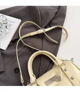 Detail showing the adjustable slim shoulder strap and silver rivets on the yellow pillow bag