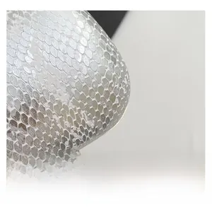 Macro shot of silver metallic snake pattern fabric texture with refined scale embossing
