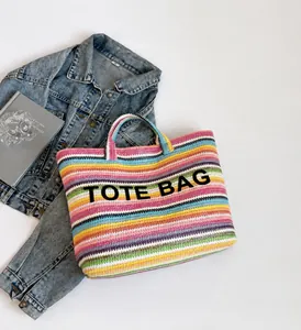 Detailaufnahme der bunten gestreiften Stroh-Tragetasche mit markantem schwarzem Text