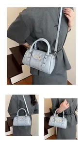Detail of light blue Boston pillow bag featuring silver studs and heart-shaped pendant charm