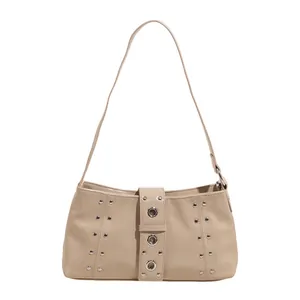 Minimalist beige baguette shoulder bag with silver rivet details and glossy finish